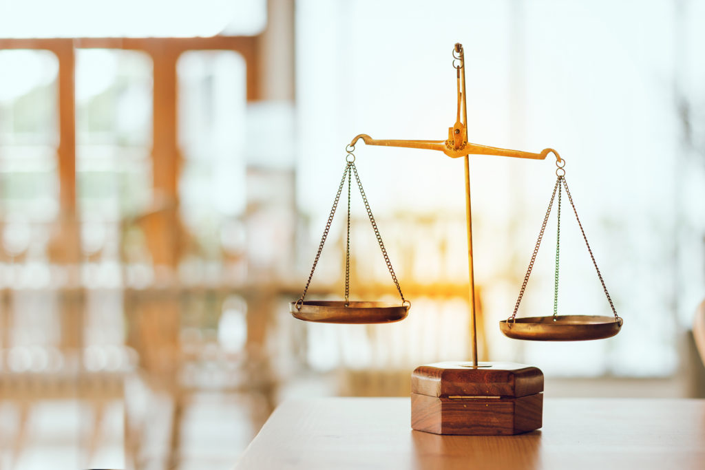 Symbol of law and scales of justice on wooden table in Legal off
